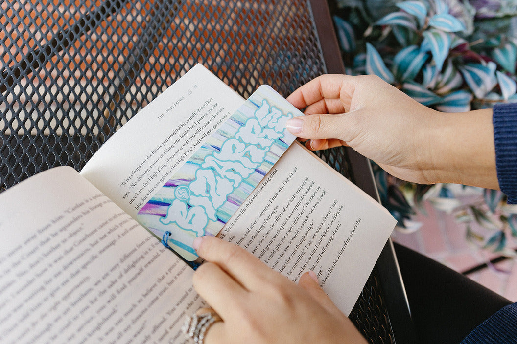 A Bizarre Coffee Bookmark, with a person read a book outside.