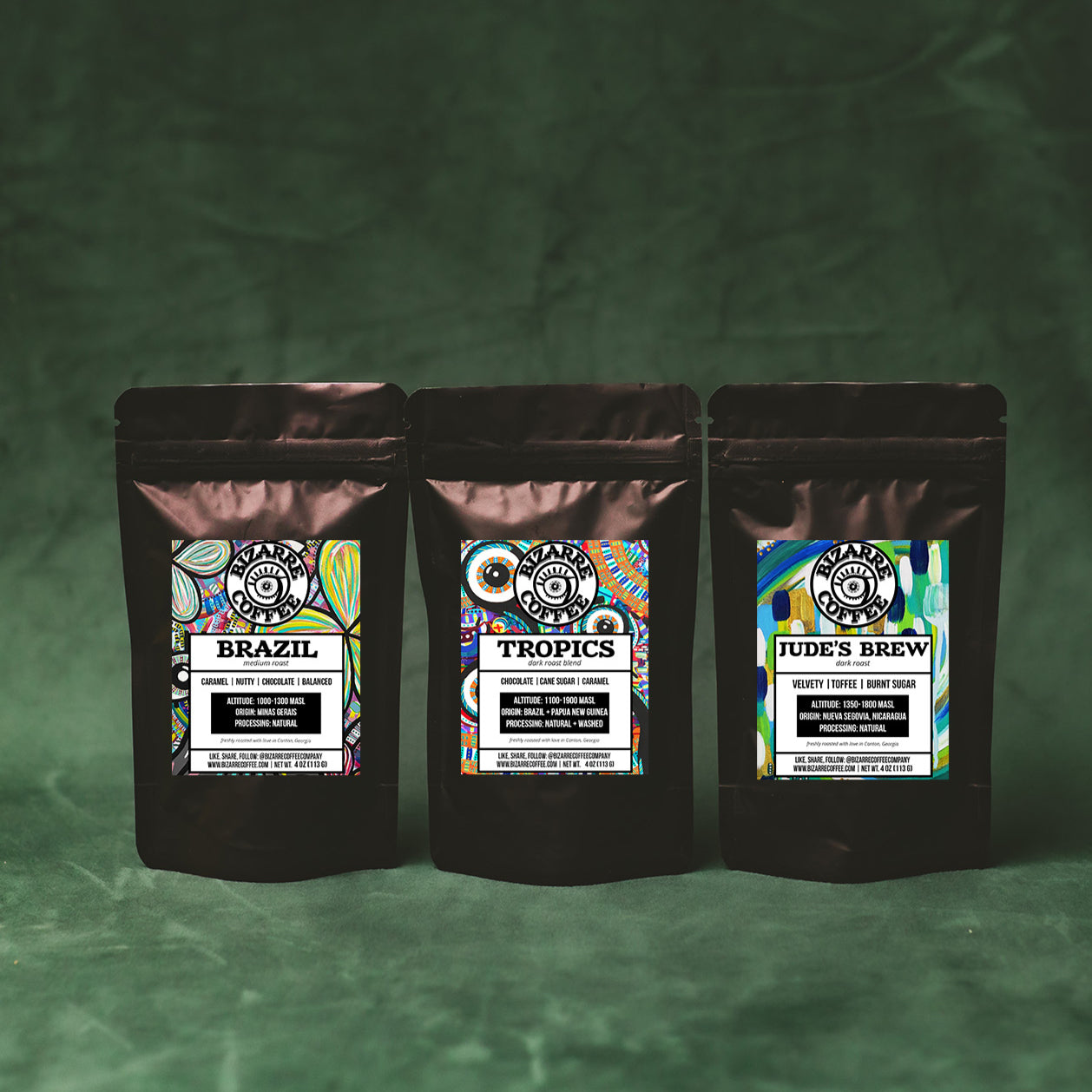 Three coffee bags with colorful labels on a green textured background