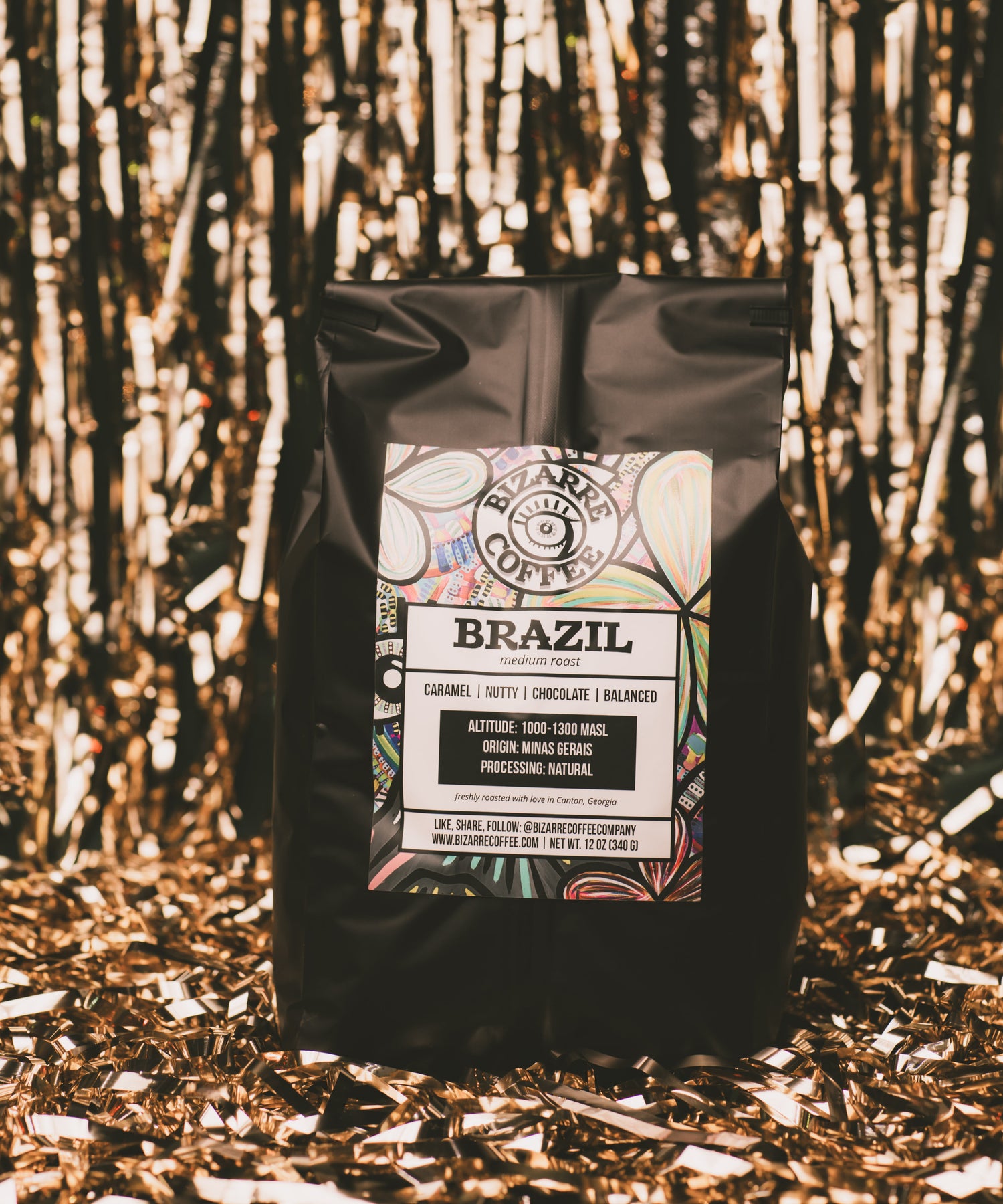 Black coffee bag labeled 'Brazil' on a textured gold background