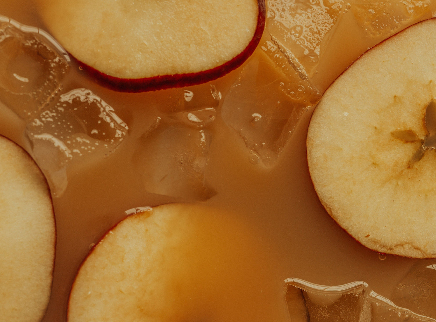 A close up image of apple slices in iced coffee.