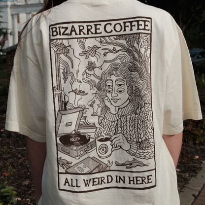 Beige t-shirt with a graphic design of a person with a record player and text &