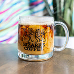 A glass mug that says Bizarre Coffee and displays dancing flowers in black.