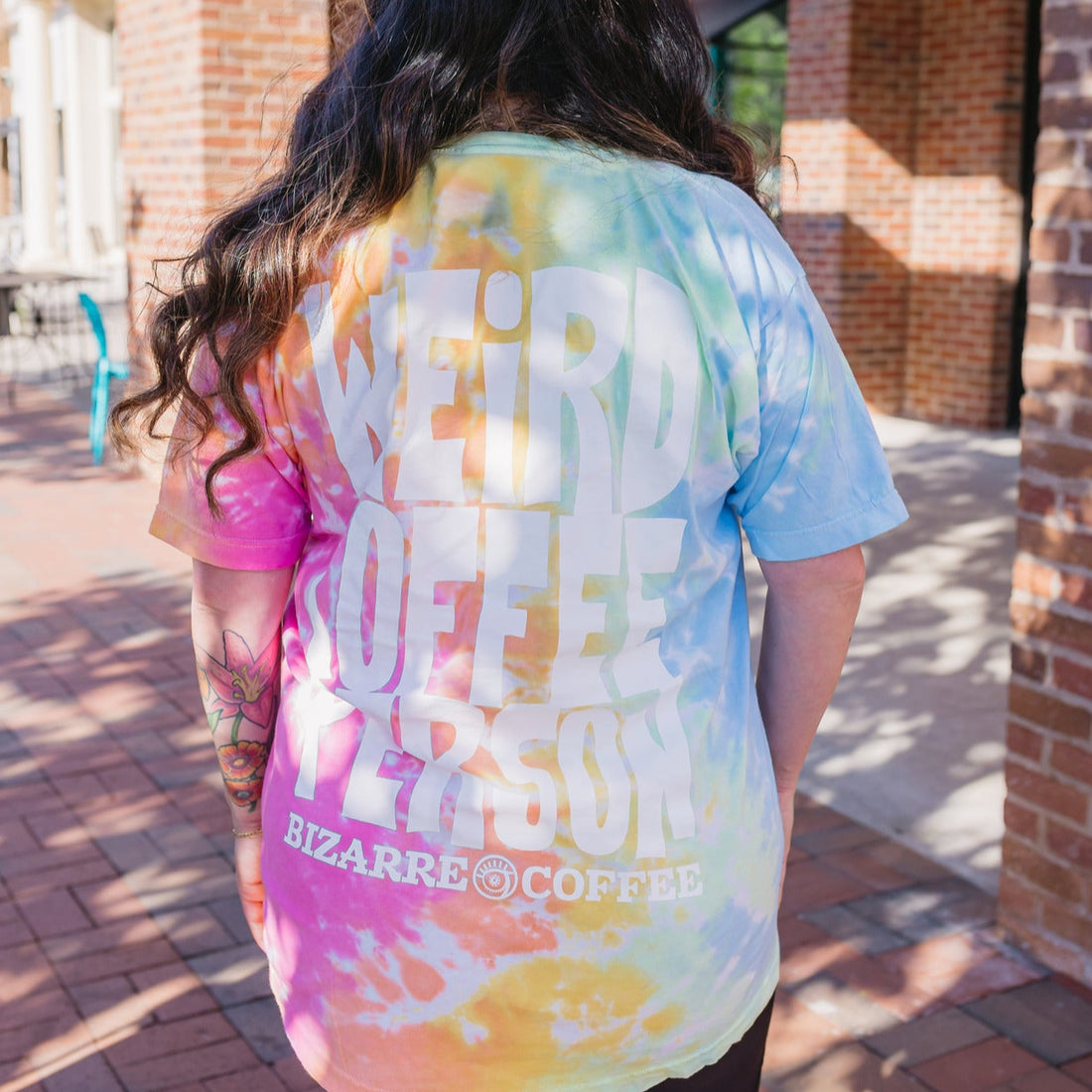 Person wearing a tie-dye t-shirt with &