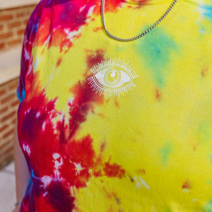 Person wearing a colorful tie-dye shirt with a white eye design.