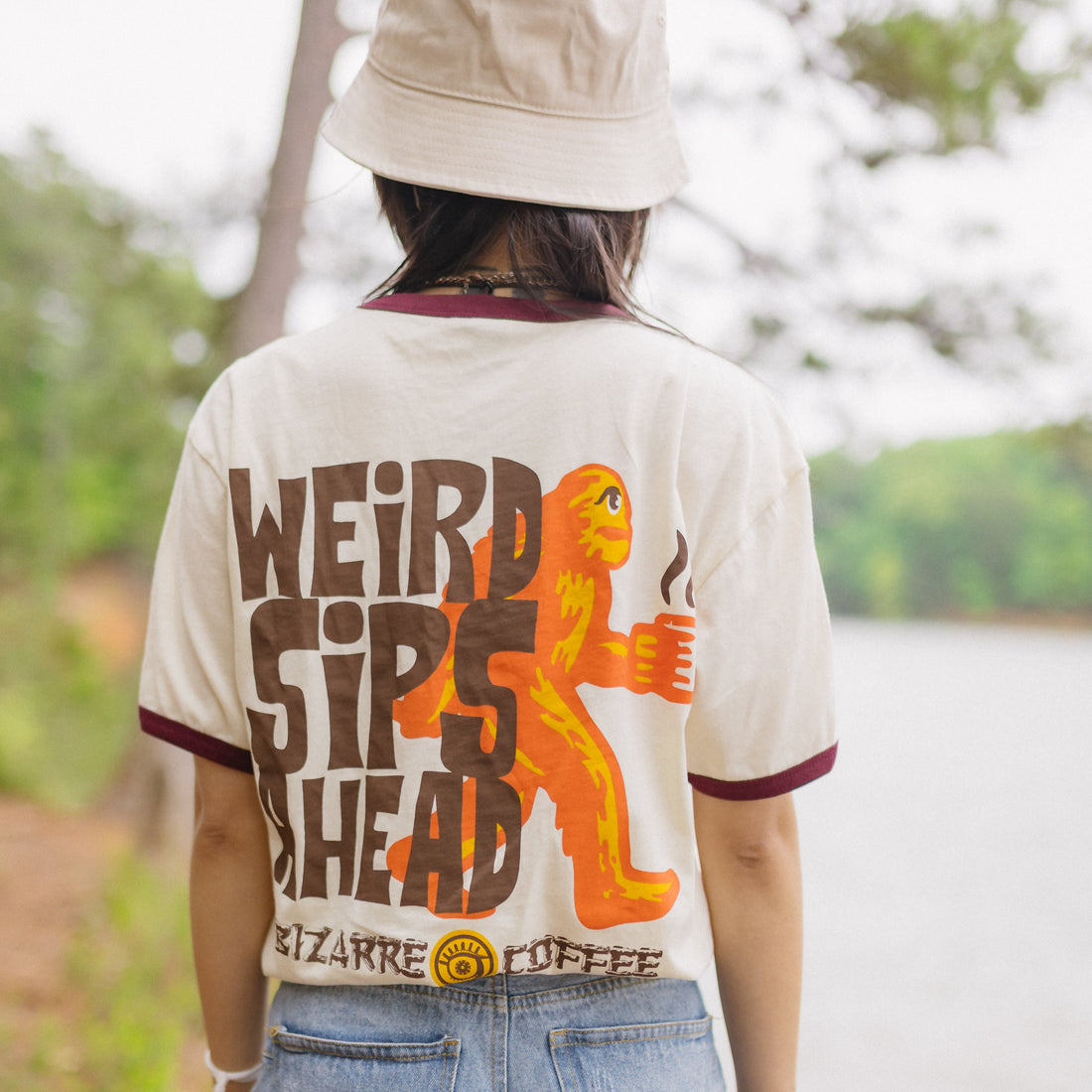A t-shirt that says weird sips ahead with big foot holding a coffee cup.