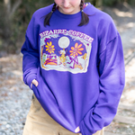 A Bizarre Coffee purple crewneck that displays a campfire and two flowers roasting marshmallows while sipping coffee. 