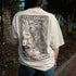 Person wearing a white t-shirt with a graphic design and text, standing outdoors.
