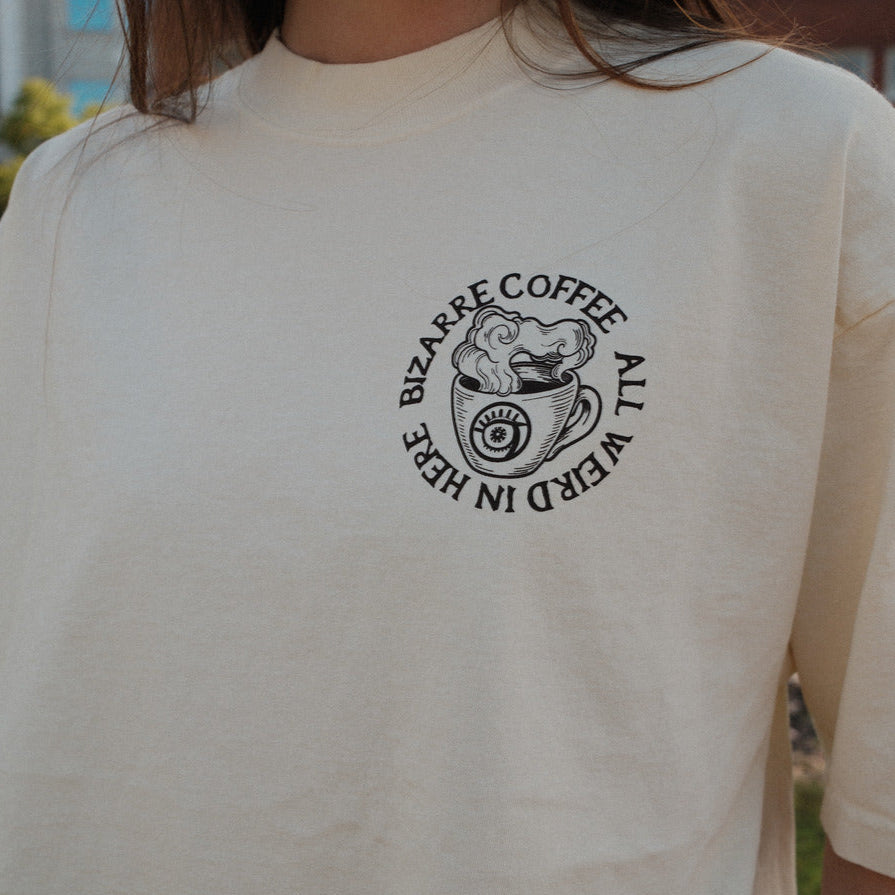 Person wearing a white t-shirt with a graphic design on the back, standing outdoors.